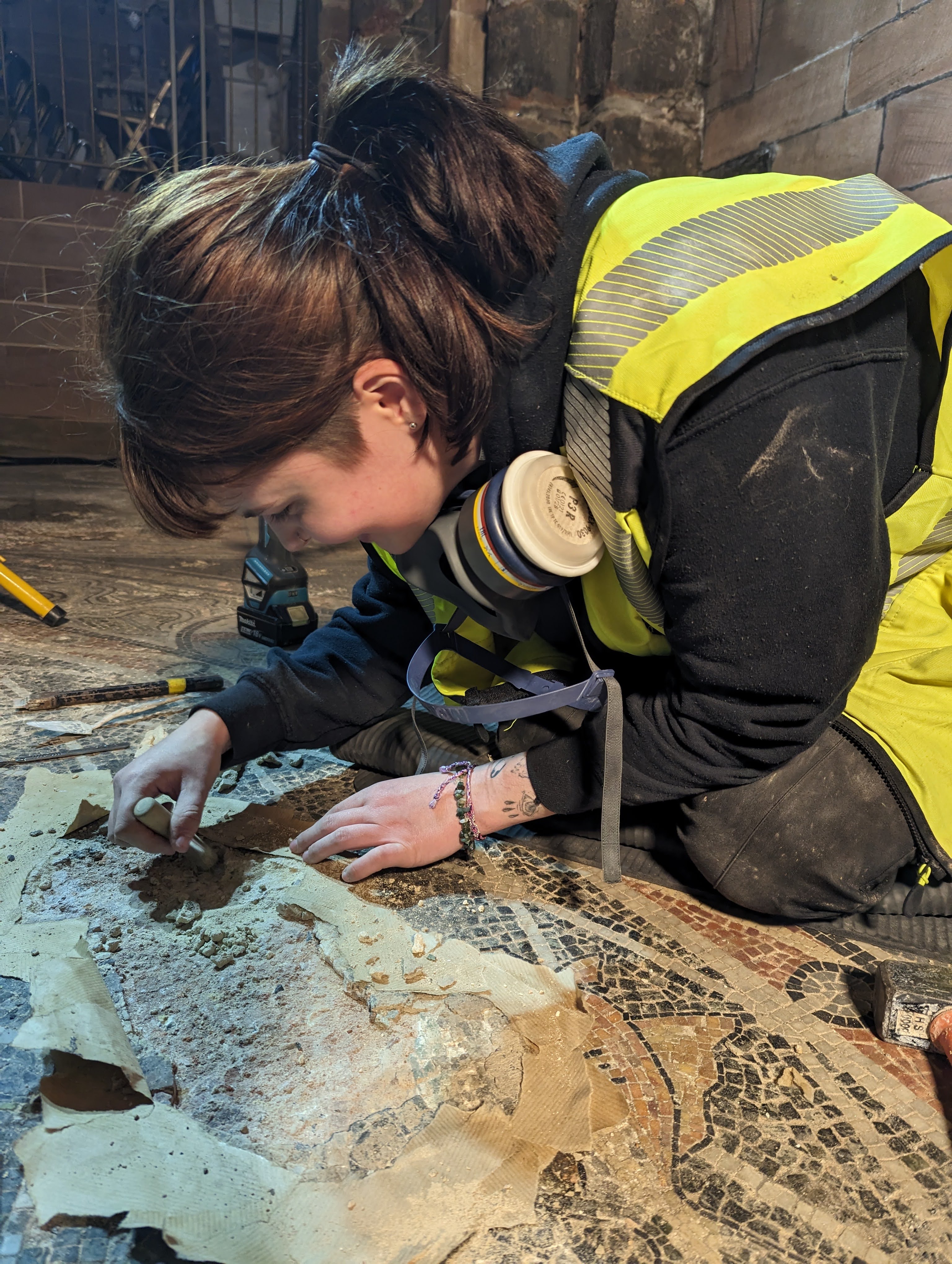 A young person inspects a mosaic floor.
