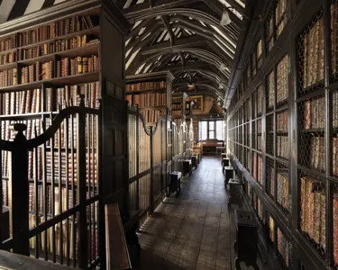 Interior view of an old library, looking along a wood-floored corridor line