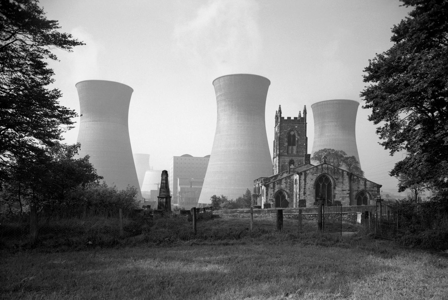 A small Gothic Revival style church sits in the foreground as three large c
