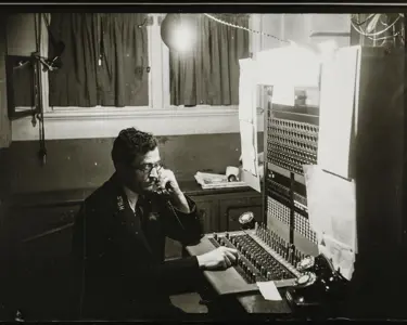 A man operating a 1940s telephone switchboard.