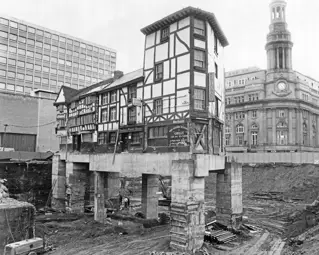 An old inn raised high off the ground on stilts whilst building works take