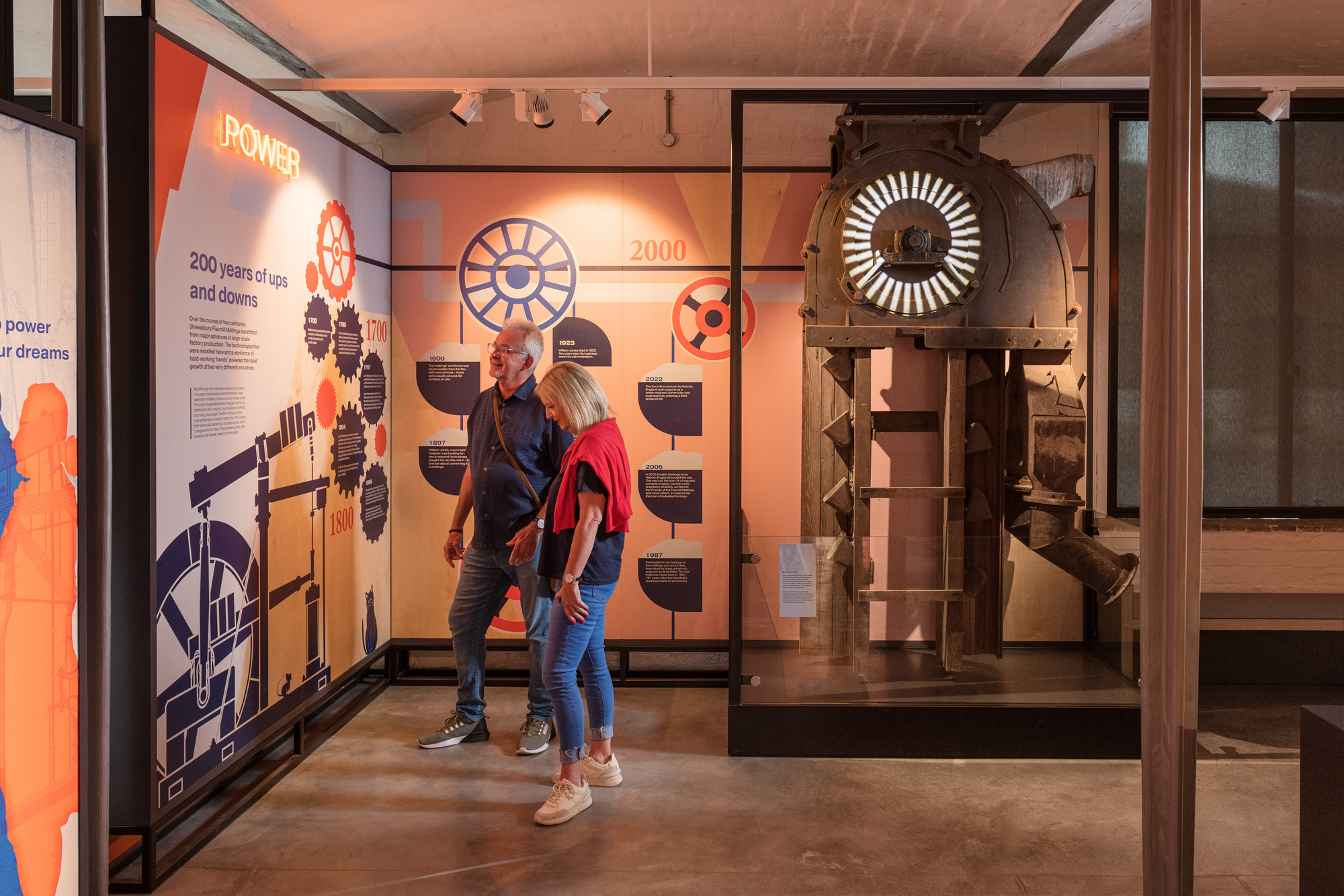 Two people reading an informative display inside Shrewsbury Flaxmill Maltin